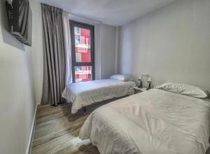 ein Schlafzimmer mit zwei Betten und einem Fenster in der Unterkunft Yan Building By CanariasGetaway in Guanarteme