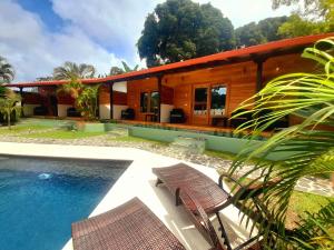 a house with a swimming pool next to a house at Tiki Lodge Hotel de Charme in Santa Catalina