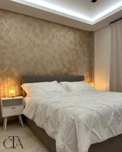 a bedroom with a white bed and a side table at Casa Tua Suriname New 4 bedroom Townhouse 14B in Paramaribo