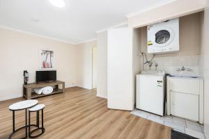 a kitchen with a refrigerator and two stools in a room at 4 Blairgowrie Apartments 4 of 2 Martin Street in Peregian Beach in Peregian Beach