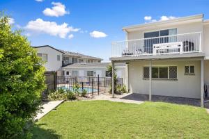 a white house with a fence and a yard at 4 Blairgowrie Apartments 4 of 2 Martin Street in Peregian Beach in Peregian Beach