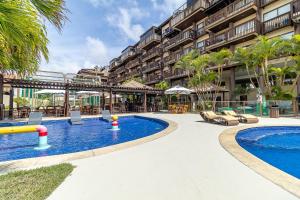 a resort swimming pool with chairs and a resort at Barra Bali Beach in Barra de São Miguel