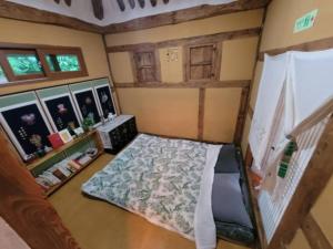 HadongHadong moonlight hanok的一间小卧室,配有一张床和一个楼梯 更多37张照片