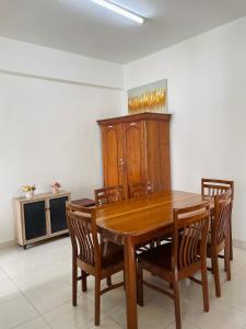 a dining room with a wooden table and chairs at Helya Homestay Wakaf Che Yeh in Kota Bharu +2 photos