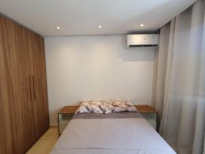 ein kleines Schlafzimmer mit einem Bett und einem Schrank in der Unterkunft Apartamento centro de São Pedro da aldeia ao lado do comércio e a 500 metros da orla da lagoa in São Pedro da Aldeia