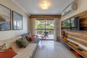 a living room with a couch and a flat screen tv at Barra Bali Beach in Barra de São Miguel
