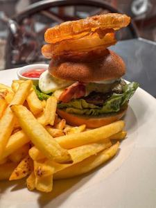 a hamburger and french fries on a white plate at Rose and Crown B&B in Burwash