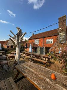 a group of picnic tables and a tree on a deck at Rose and Crown B&B in Burwash