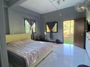 a bedroom with a bed and some windows at วิวดี ป่าเหมี้ยง โฮมสเตย์ in Ban Pa Miang