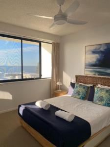 a bedroom with a bed with a ceiling fan at Kings Row Apartments in Caloundra