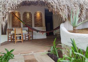 a house with a hammock outside of it at Posada Las Tortuguitas in Mazunte +5 photos
