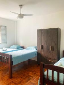 a bedroom with two beds and a dresser at Apto grande na pompeia in Sao Paulo