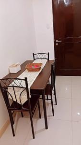 una mesa de madera y sillas con una mesa y una puerta en Northpoint CozyHome, en Davao City