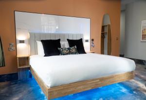 a bedroom with a large white bed with black pillows at The Arundell Hotel in Boston