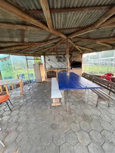 a blue ping pong table in a pavilion with tables and chairs at Quarto confortável em Imbituba in Imbituba