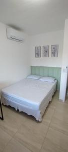 a bedroom with a bed in a white room at Condomínio Ecoville das Mangueiras Região de Praia de Guarajuba in Camacari