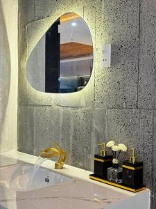 a bathroom with a round mirror and a sink at Cy sea villa 3 in Da Nang