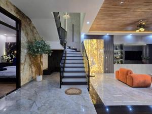 a staircase in a house with an orange couch at Cy sea villa 3 in Da Nang