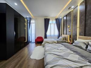 a bedroom with two beds and a red chair at Cy sea villa 3 in Da Nang