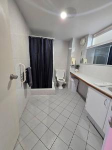a bathroom with a toilet and a sink and a shower at Oasis Mandurah Resort in Mandurah