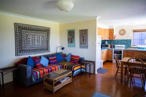 a living room with a couch and a kitchen at Absolute Beachfront Mollymook in Mollymook