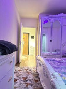 Kosovo PoljeにあるLysa Apartmentの紫色のベッドルーム(ベッド1台、ドレッサー付)