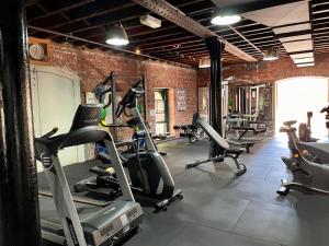 a gym with several tread machines in a brick wall at Melbourne Riverside Retreat in Melbourne