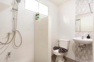 a white bathroom with a toilet and a sink at Comfy Corner Hotel in Chiang Mai +12 photos