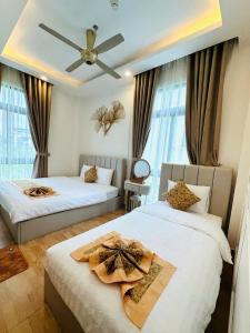 a bedroom with two beds and a ceiling fan at Hạ Tím Villa in Xuan An