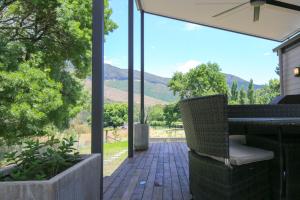 d'une terrasse avec une table, des chaises et des montagnes. dans l'établissement Cranmore Cottage, à Bright