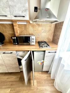 a small kitchen with a stove and a microwave at Бухар -Жырау 72 in Karagandy