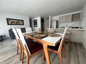 a dining room and kitchen with a table and chairs at Comodo Apto Diagonal MALL PLAZA in Manizales