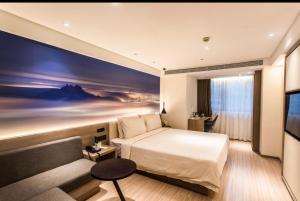 a hotel room with a bed and a flat screen tv at Atour Hotel Nanjing Xinjiekou Daxinggong Subway Station in Nanjing