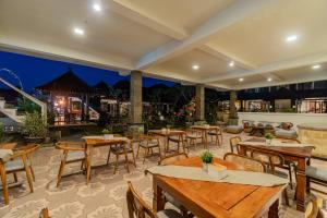 ウブドにあるPondok Wana Ubudのテーブルと椅子とバーのあるレストラン