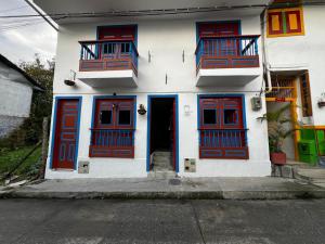 a building with red and blue doors and windows at Hospedaje in Salento