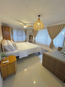 a bedroom with two beds and a chandelier at Kataleya Villa, Punclut 4BR in Bongkar 2