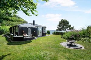 un hangar noir avec une table dans une cour dans l'établissement Beautiful Holiday Home With Panoramic Views Over Ebeltoft Bay, à Ebeltoft