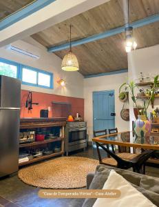 a kitchen with a table and a refrigerator in a room at Minha Casa em Caraíva, no centro da vila in Caraíva