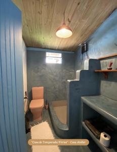 a bathroom with a toilet and a blue wall at Minha Casa em Caraíva, no centro da vila in Caraíva +10 photos
