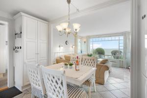 une salle à manger et un salon avec une table et des chaises dans l'établissement Beautiful Holiday Home With Panoramic Views Over Ebeltoft Bay, à Ebeltoft