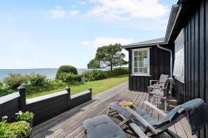 une terrasse avec des chaises et une maison donnant sur l'océan dans l'établissement Beautiful Holiday Home With Panoramic Views Over Ebeltoft Bay, à Ebeltoft 32 autres photos