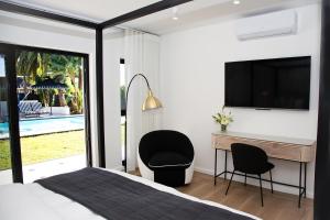 una camera da letto con un letto, una scrivania e una TV di Coco Queen a Paarl