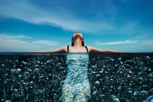 a woman is floating in the water at Marina Bay Sands in Singapore