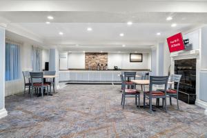 a room with tables and chairs and a kitchen at Red Roof Inn Auburn Hills in Auburn Hills