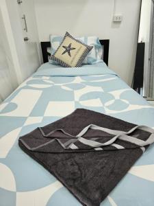 a bedroom with a bed with a blanket on it at Haru Inn Airport in Ban Bo Han