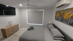 ein Schlafzimmer mit großem Bett und Fenster in der Unterkunft Bali Elliott Heads - Coastal Holiday Home near Boat Ramp in Elliott Heads