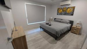 ein Schlafzimmer mit einem Bett und einem großen Fenster in der Unterkunft Bali Elliott Heads - Coastal Holiday Home near Boat Ramp in Elliott Heads