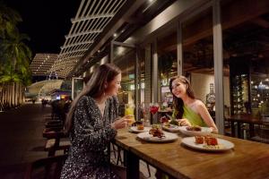 two women sitting at a table with plates of food at Marina Bay Sands in Singapore