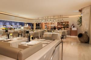 a restaurant with white tables and chairs and a chef in the background at Marina Bay Sands in Singapore