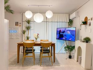 a dining room with a table and chairs and a tv at Sha lala stay in Seoul